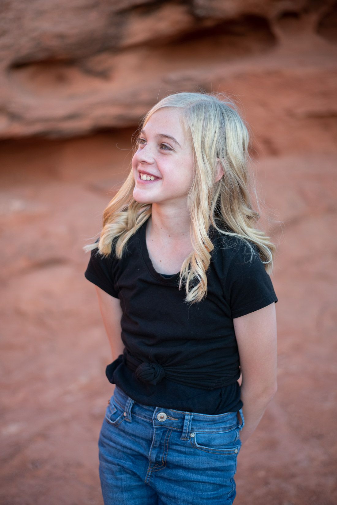 Girl with hands behind her back looking to the side