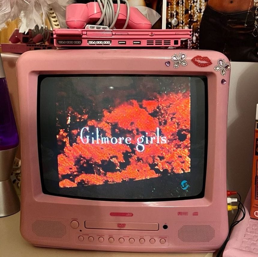 A pink TV with a DVD slot, showing Gilmore Girls on the small screen.