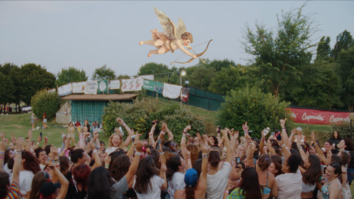 A screengrab of a group of 100 girls, all Harry Styles fans, jumping and singing in a field before a concert. An illustration of Cupid is aiming down at the group.