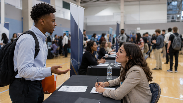 A student talks with a recruiter at a college career fair table