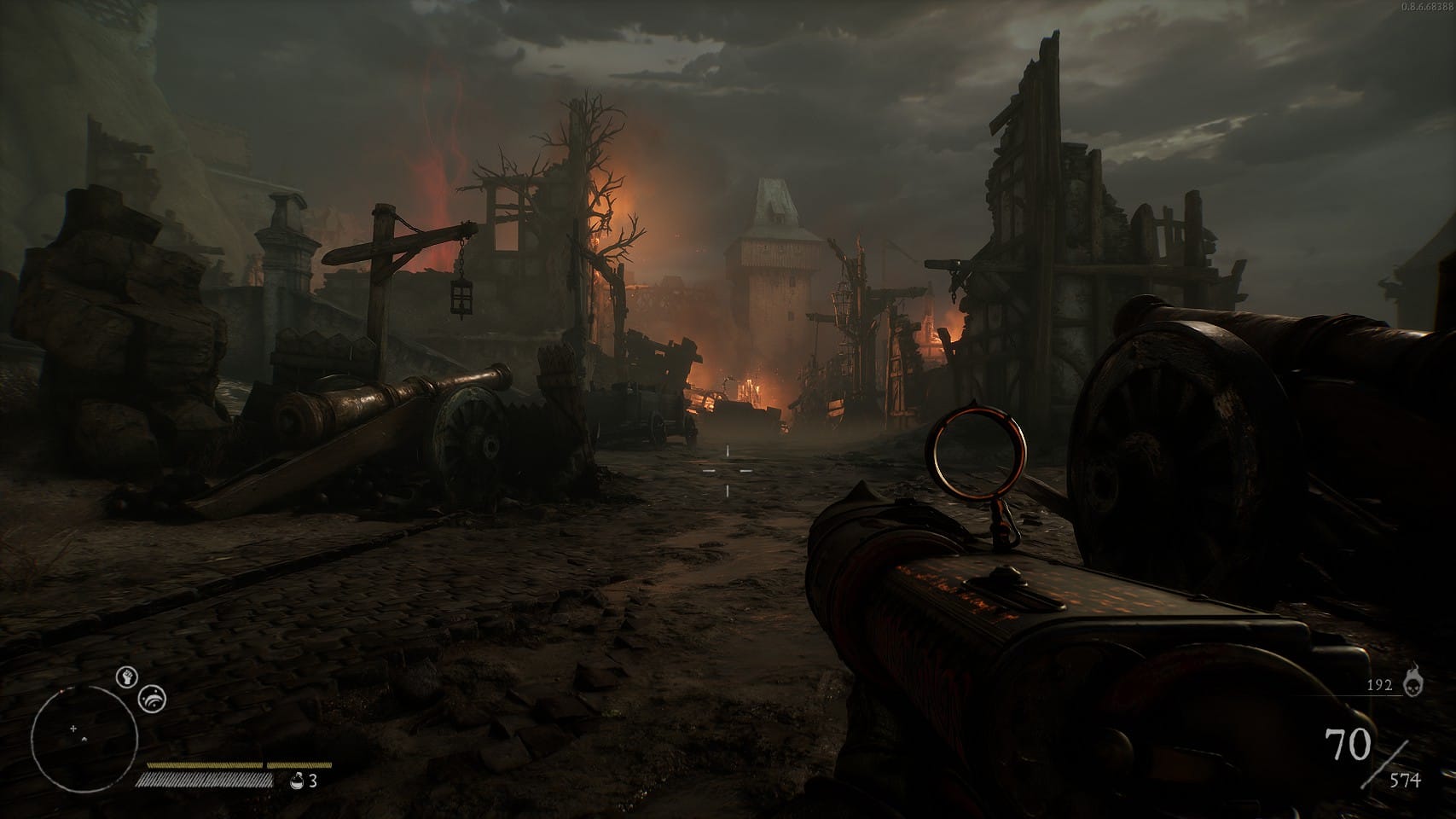 The player looks over a muddy road with many ruined houses and some distant flames glowing beyond.