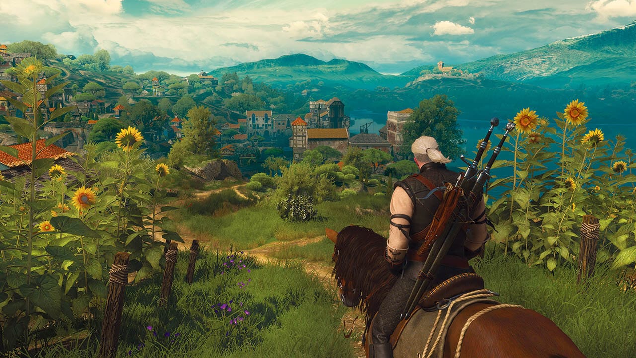 Geralt on his horse, on a hill overlooking the setting of the Blood & Wine DLC, which looks lush and welcoming.