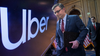 In a composite image, Uber’s logo appears on a screen next to Speaker Mike Johnson at the Capitol building.