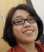 Picture of Ida, smiling, a woman with short black hair, glasses and brown skin.