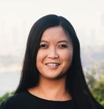 Picture of Ria, a woman a slight smile and brown skin, her face framed by her long black hair.