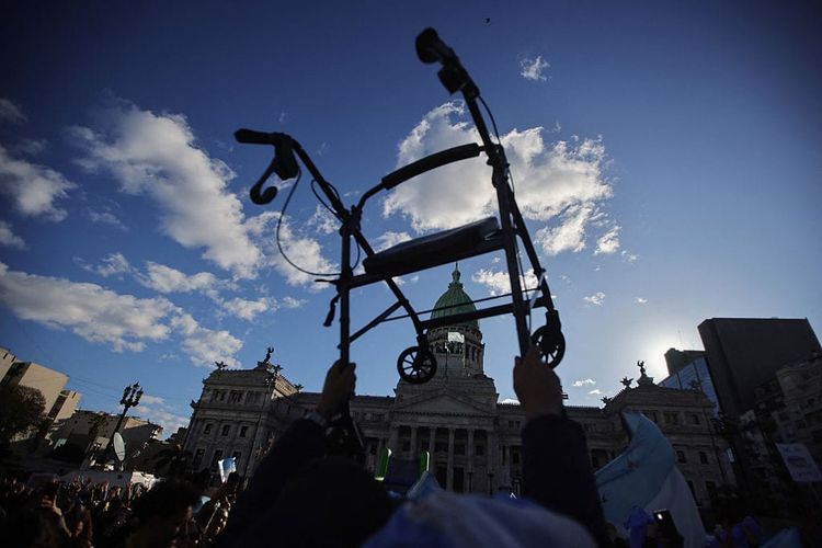 A photo of a walker being held in the air in front of the Argentine National Congress.