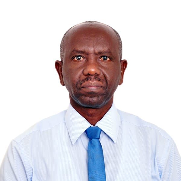Formal profile picture of Evariste, a middle aged black man looking somber. He is balding with a thin stubble of greying hair. He wears a formal shirt and blue tie. 