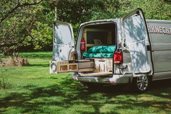 Gehuurde kampeerbox met bed en buitenkeuken in een bestelwagen