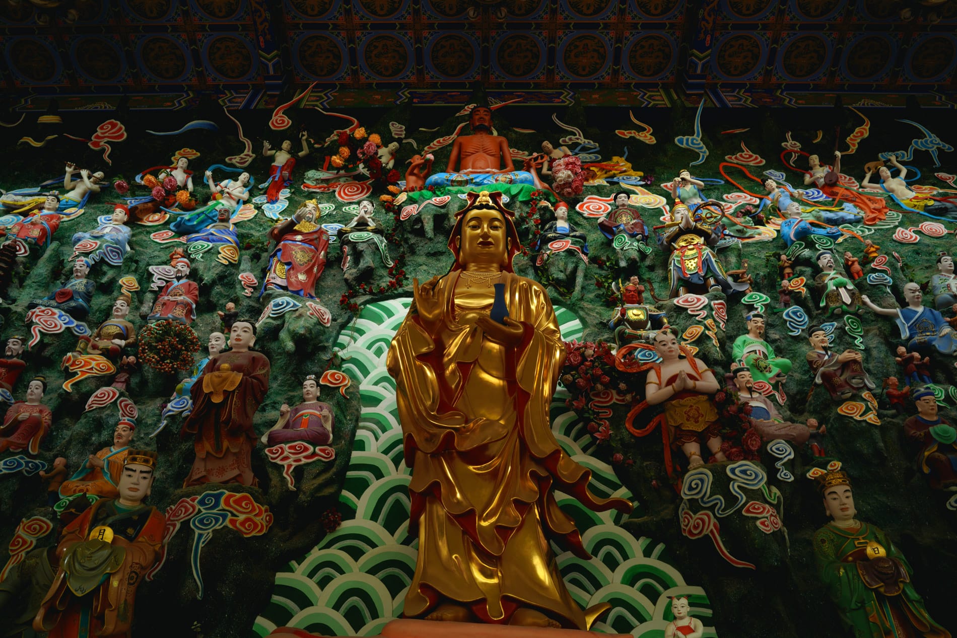 Dozens of Buddhist idols staring down from wall