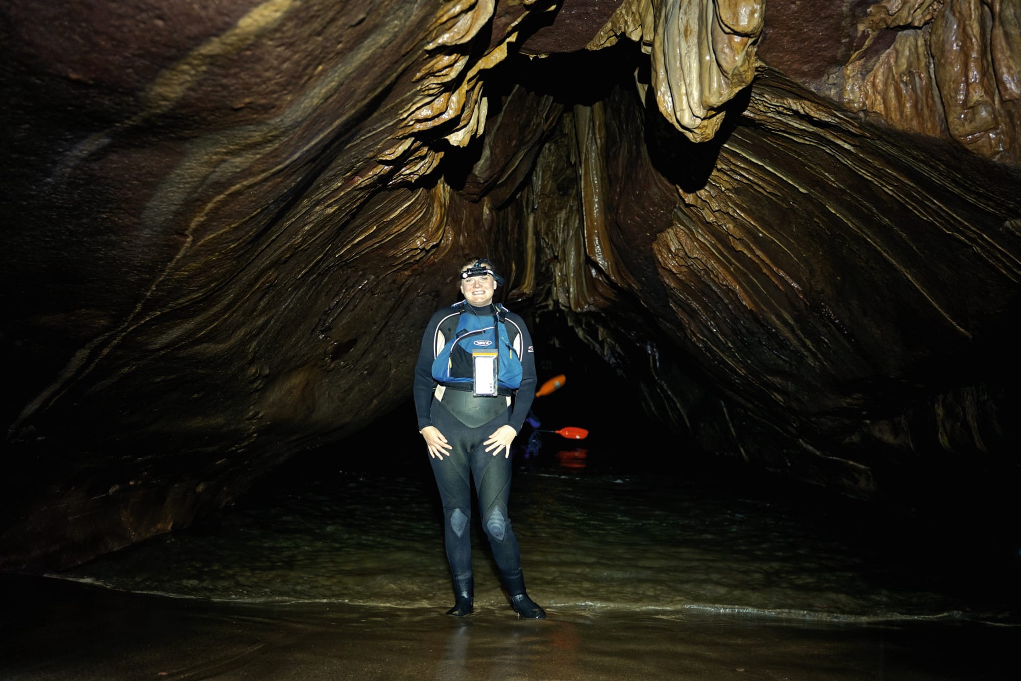 Jacki is standing in a dark cave.