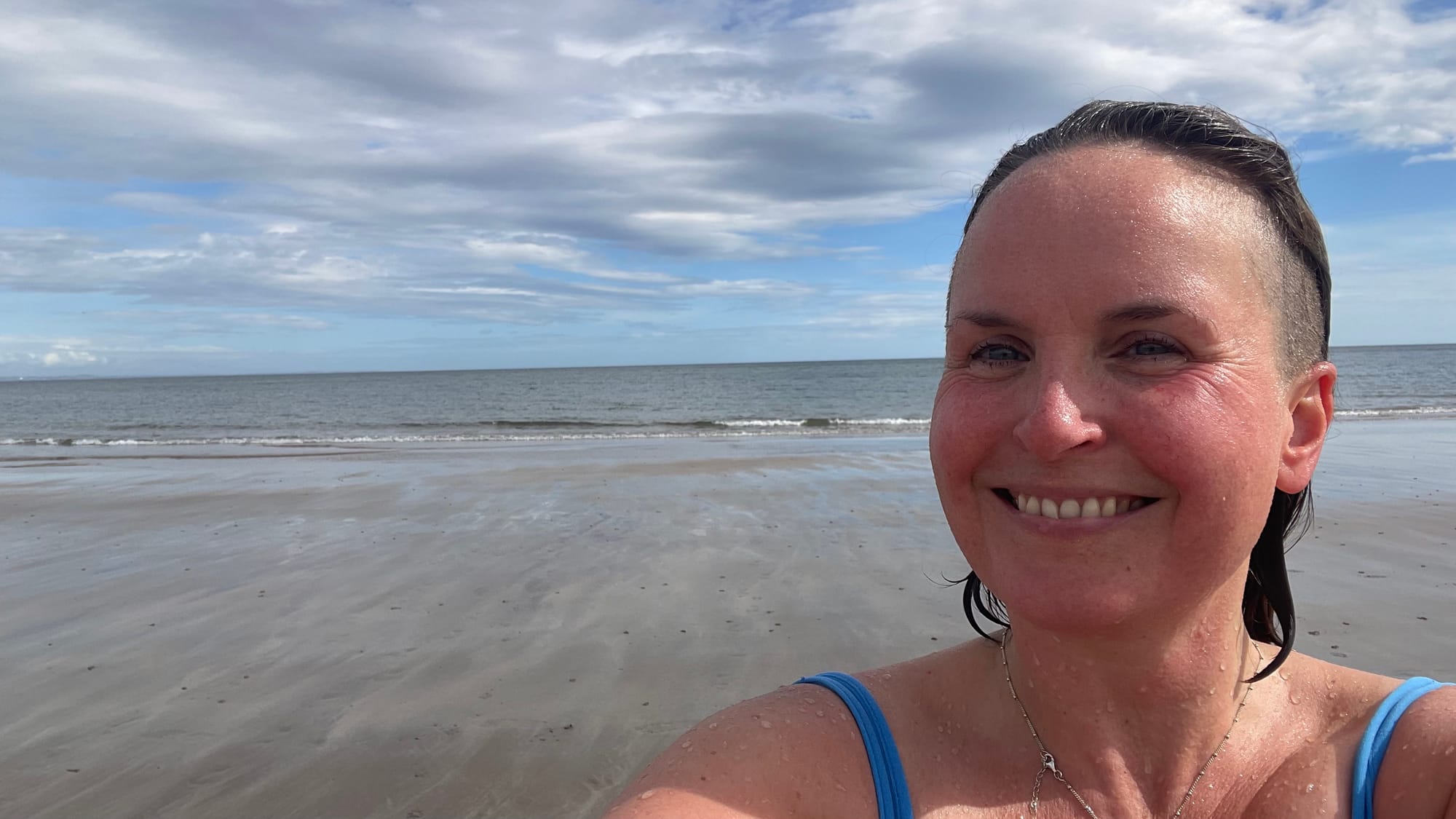 Rachel smiles for a selfie in the blue water at East Sands.