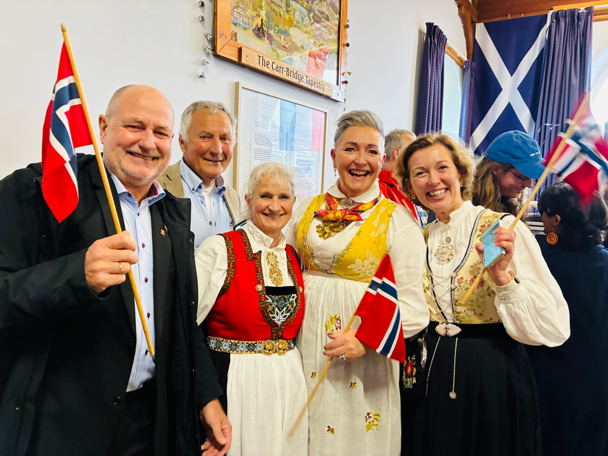 The Norwegian team in traditional dress holding Norwegian flags.