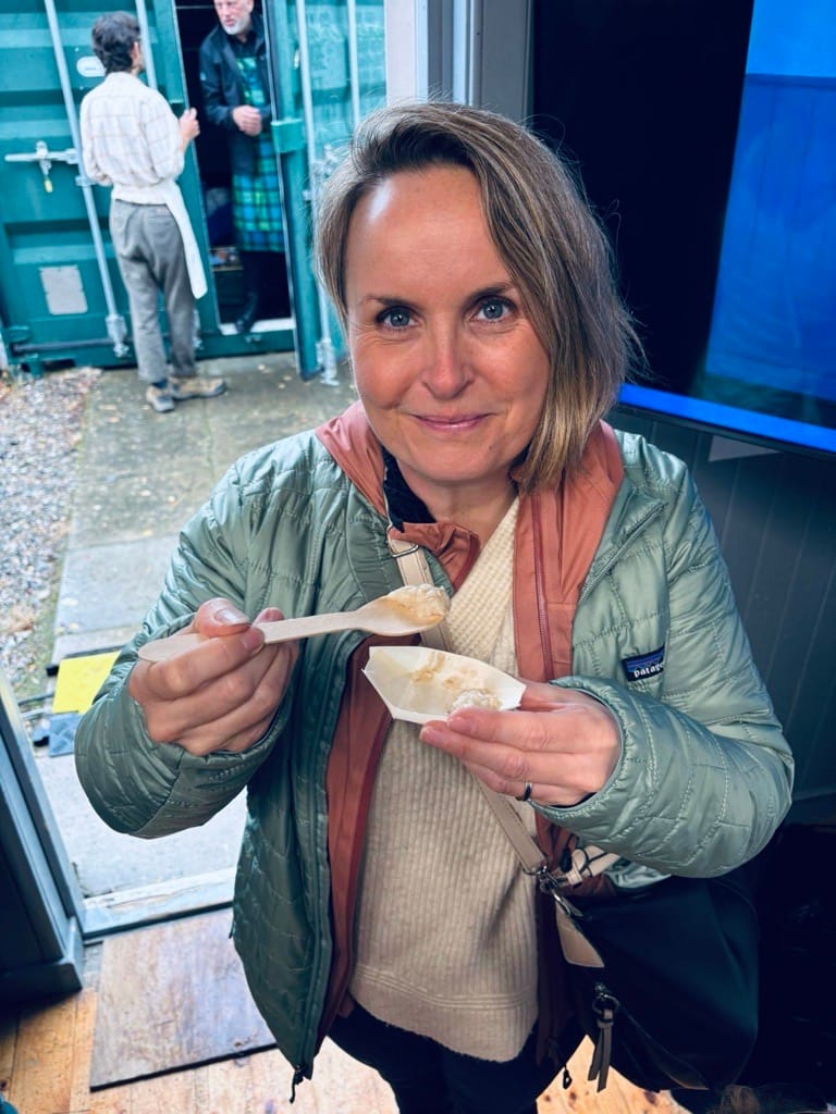 Rachel tries a small amount of porridge with a spoon.