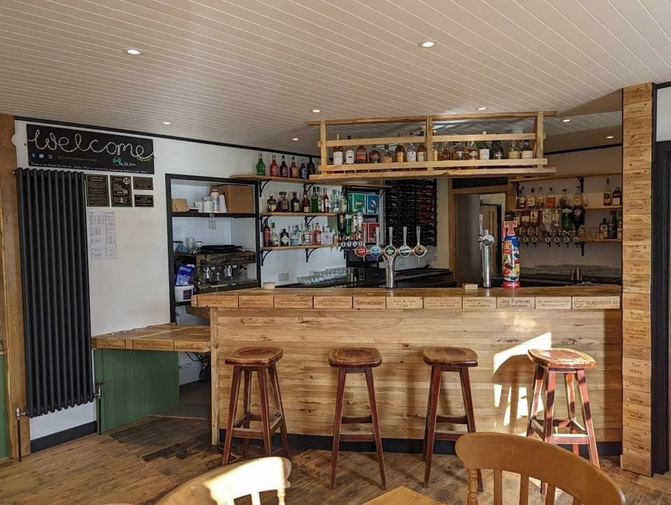 The wooden bar area in The Old Forge with a welcome sign to the left.