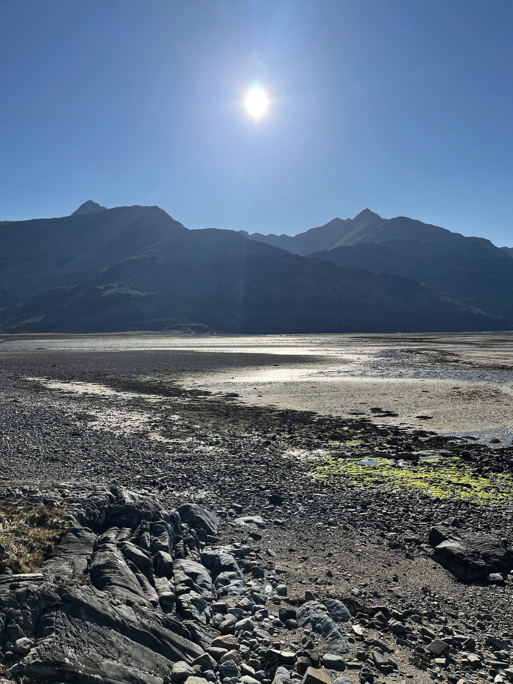 The jagged silhouette of Ladhar Bheinn with the sun rising above it from Barrisdale Bay.