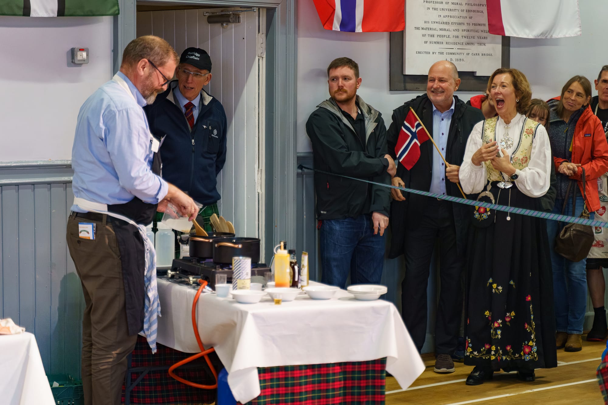 Sven cooks at his station with his family cheering him on.