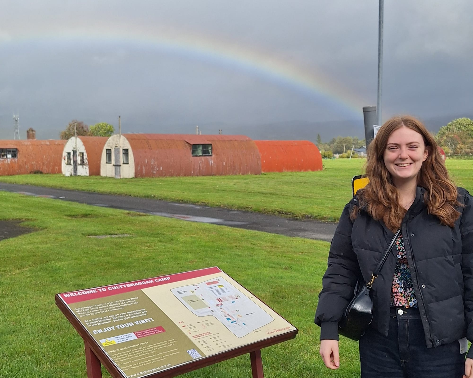 Beth smiles near the welcome sign to Cultybraggan Camp.