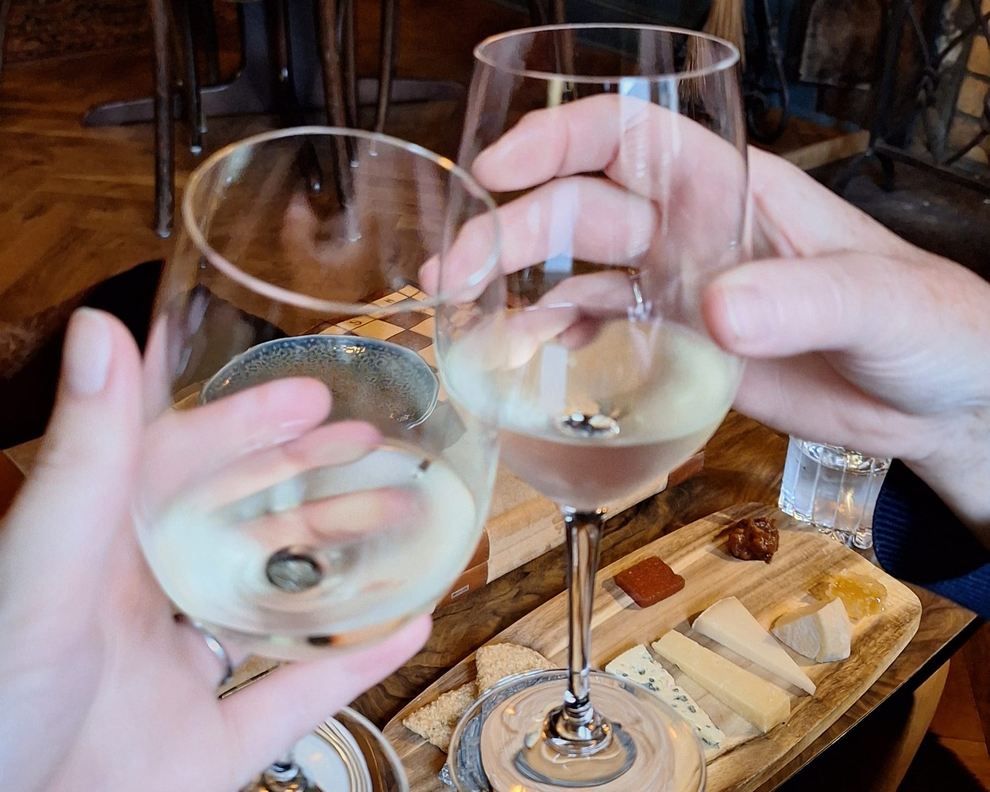 White wine glasses with the cheese board below. 