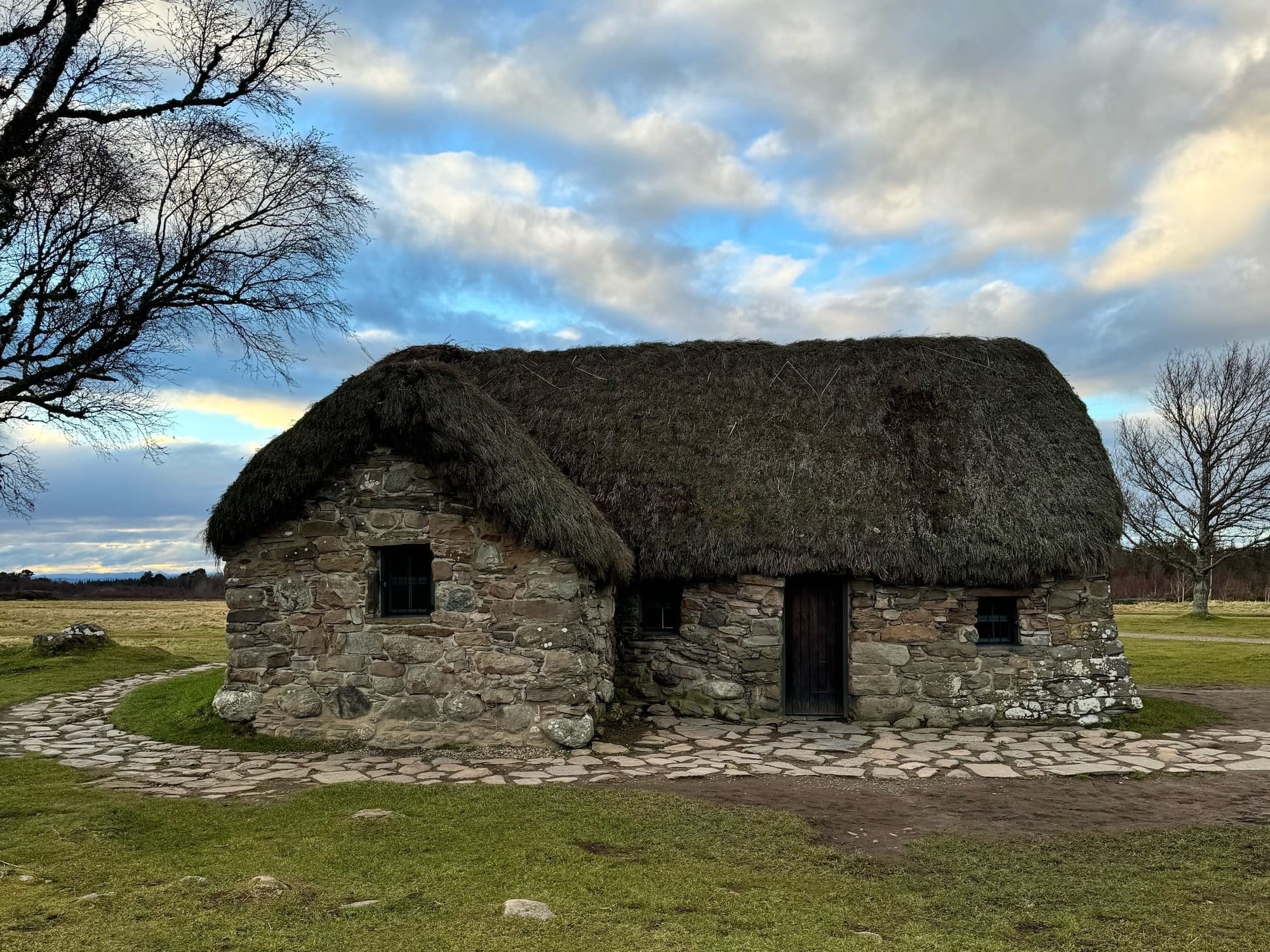 Leanach Cottage - a stone cottage with a thatched roof.