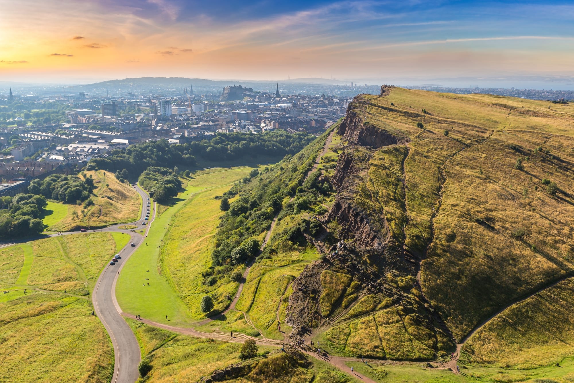 The dramatic cliff of Arthur's Seat on the right with the city of Edinburgh in the distance.