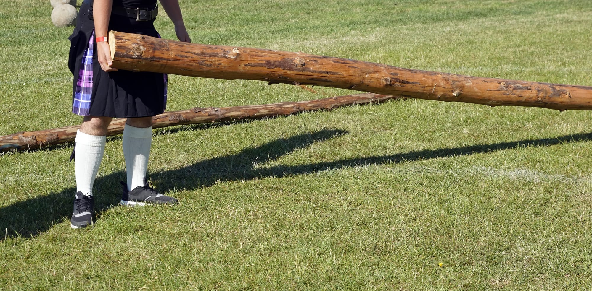 A man in a kilt holding a caber.