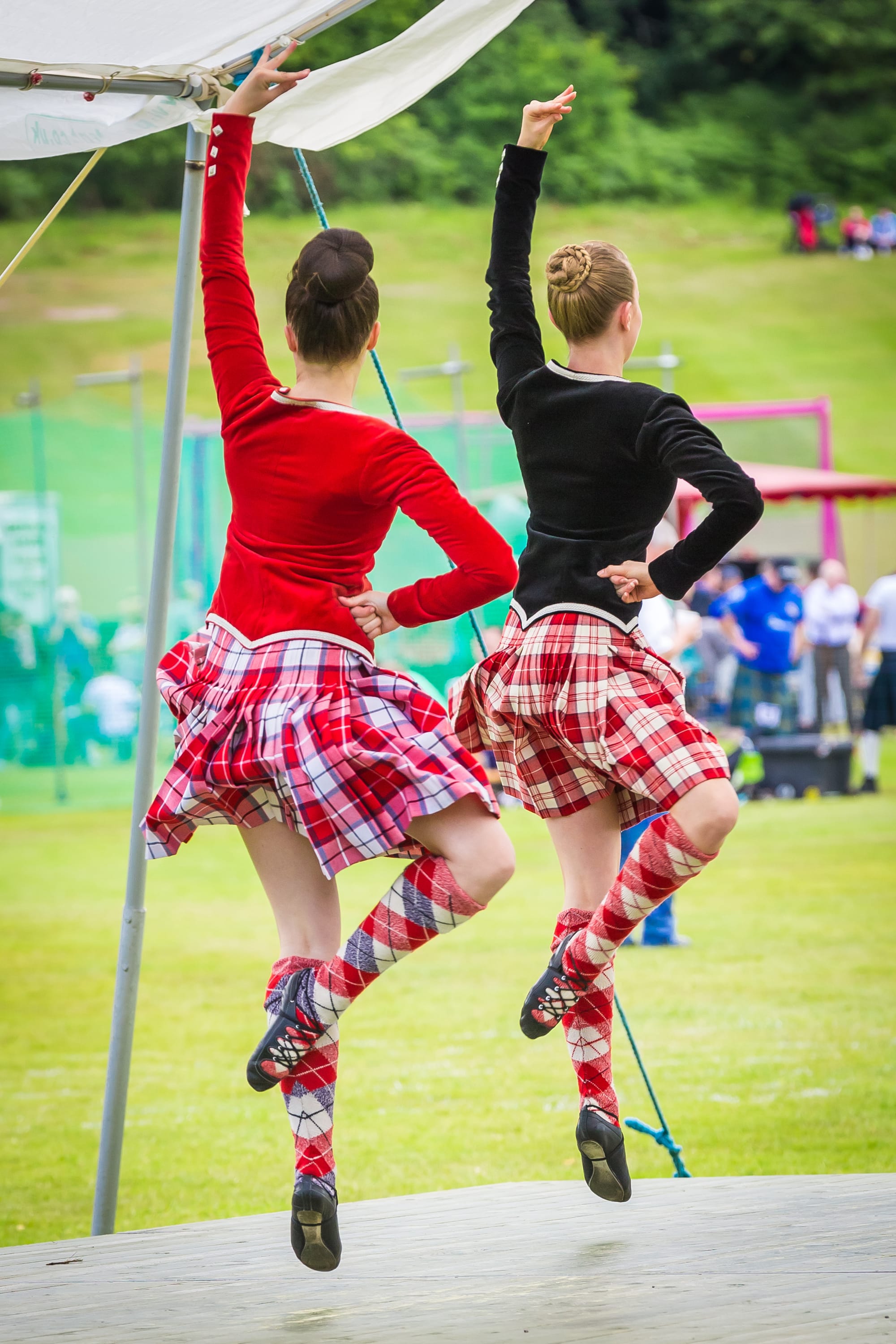 Two female dancers in red kilts.