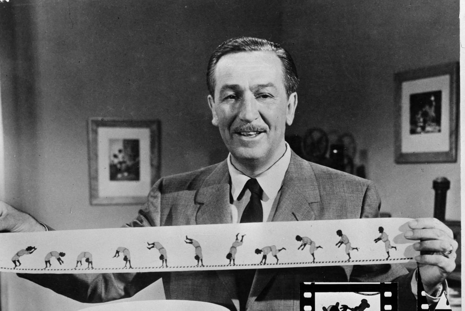 A black and white shot of Walt Disney holding a strip for a zoetrope.