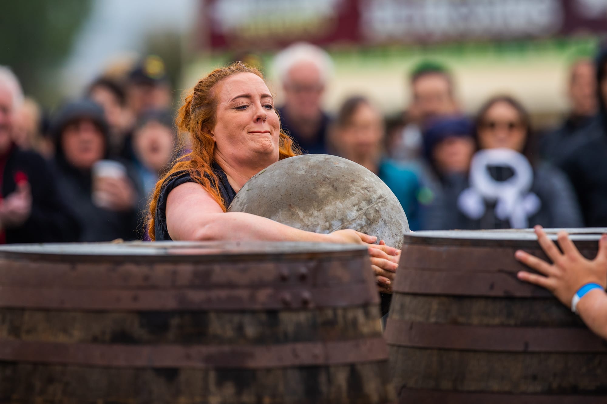 A woman participant during the Ardblair Stones contest holding one of the concrete spheres.