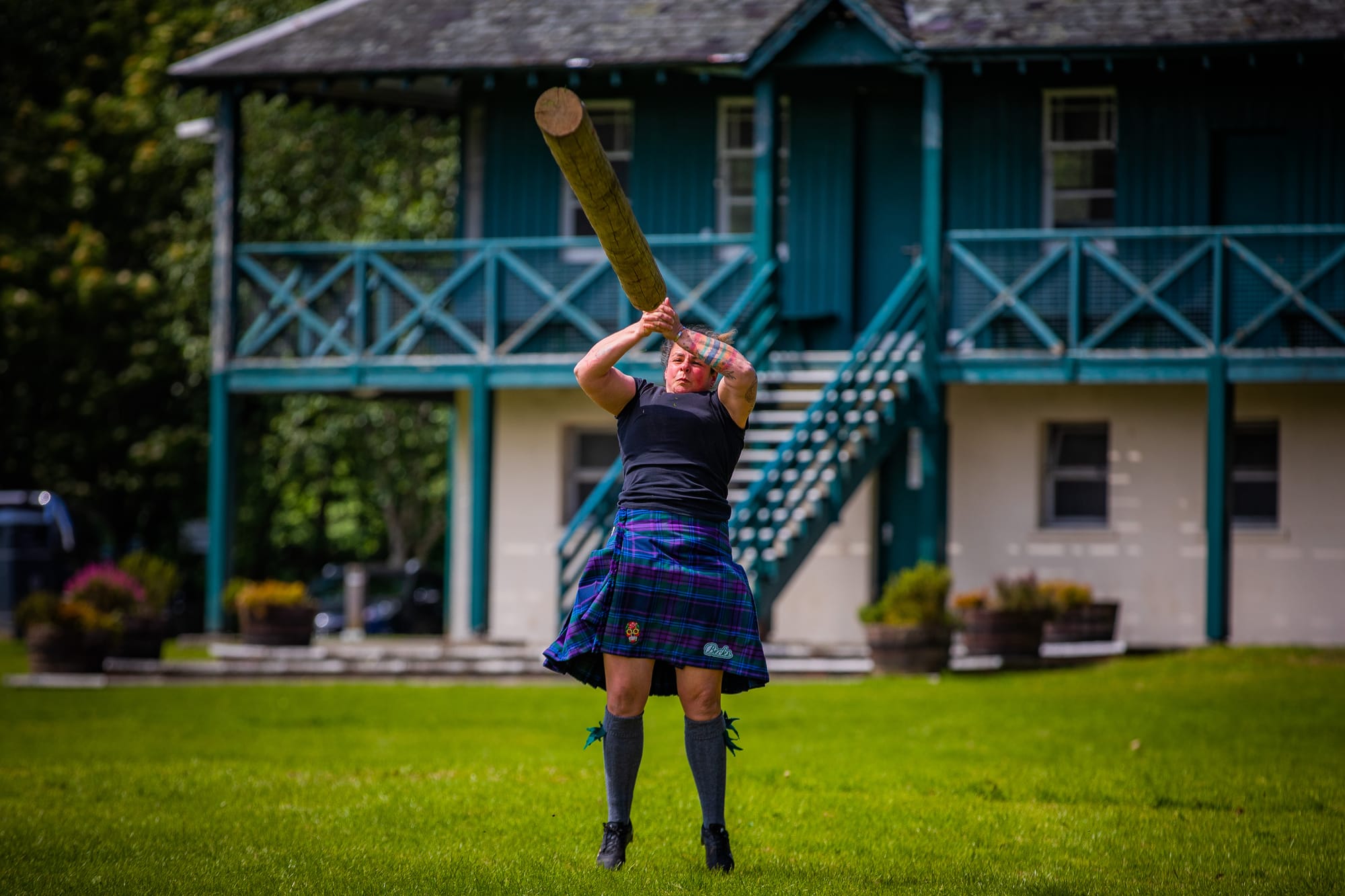 Rebecca Maeule tossing a caber while wearing a kilt.