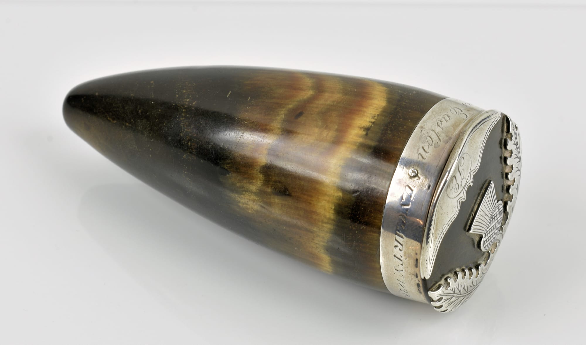 A Scottish snuff mull made from an animal horn and topped with an engraved silver lid depicting a thistle.