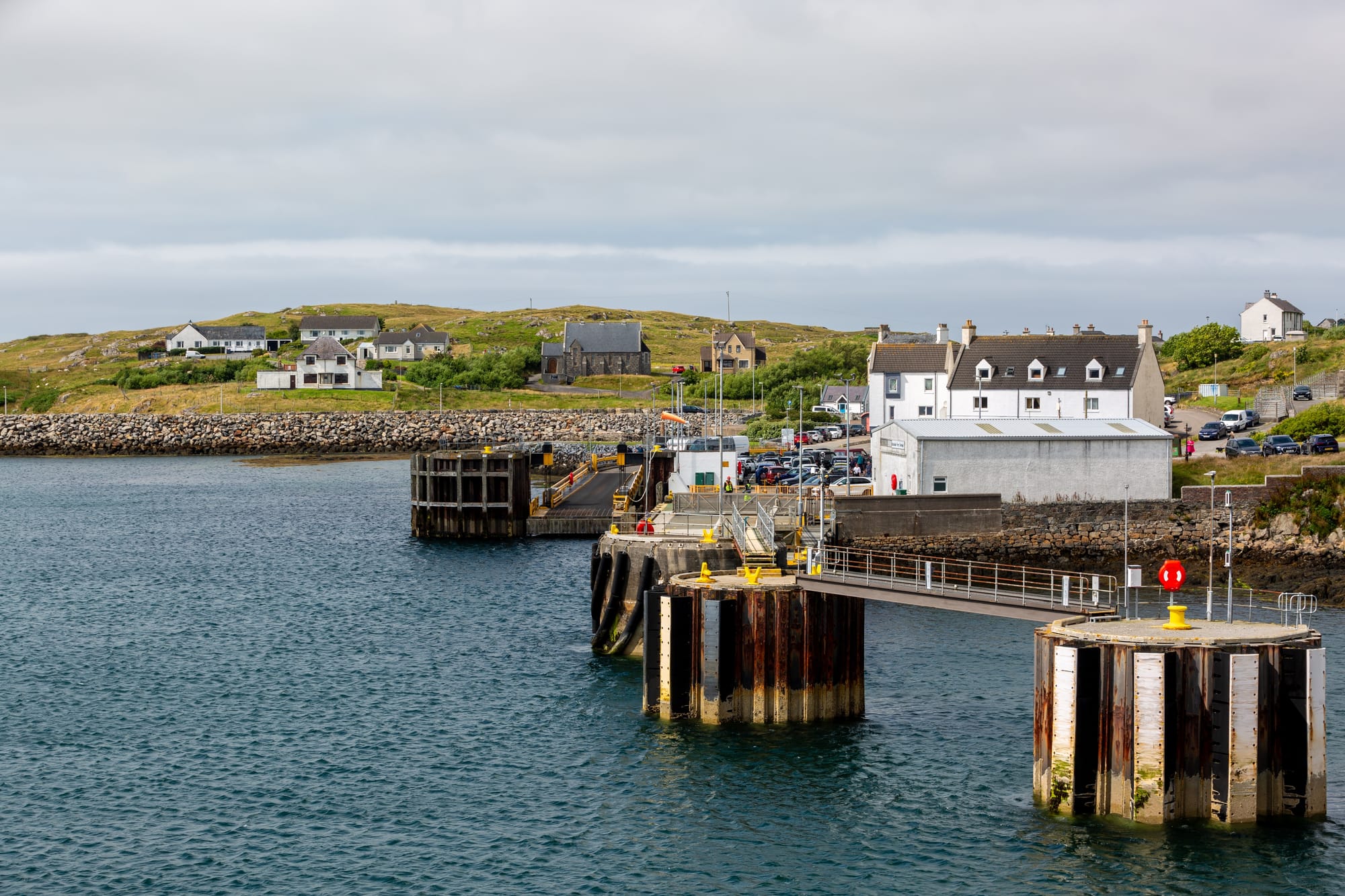 Several houses sit on a small hillside overlooking the harbour at Lochboisdale on South Uist.