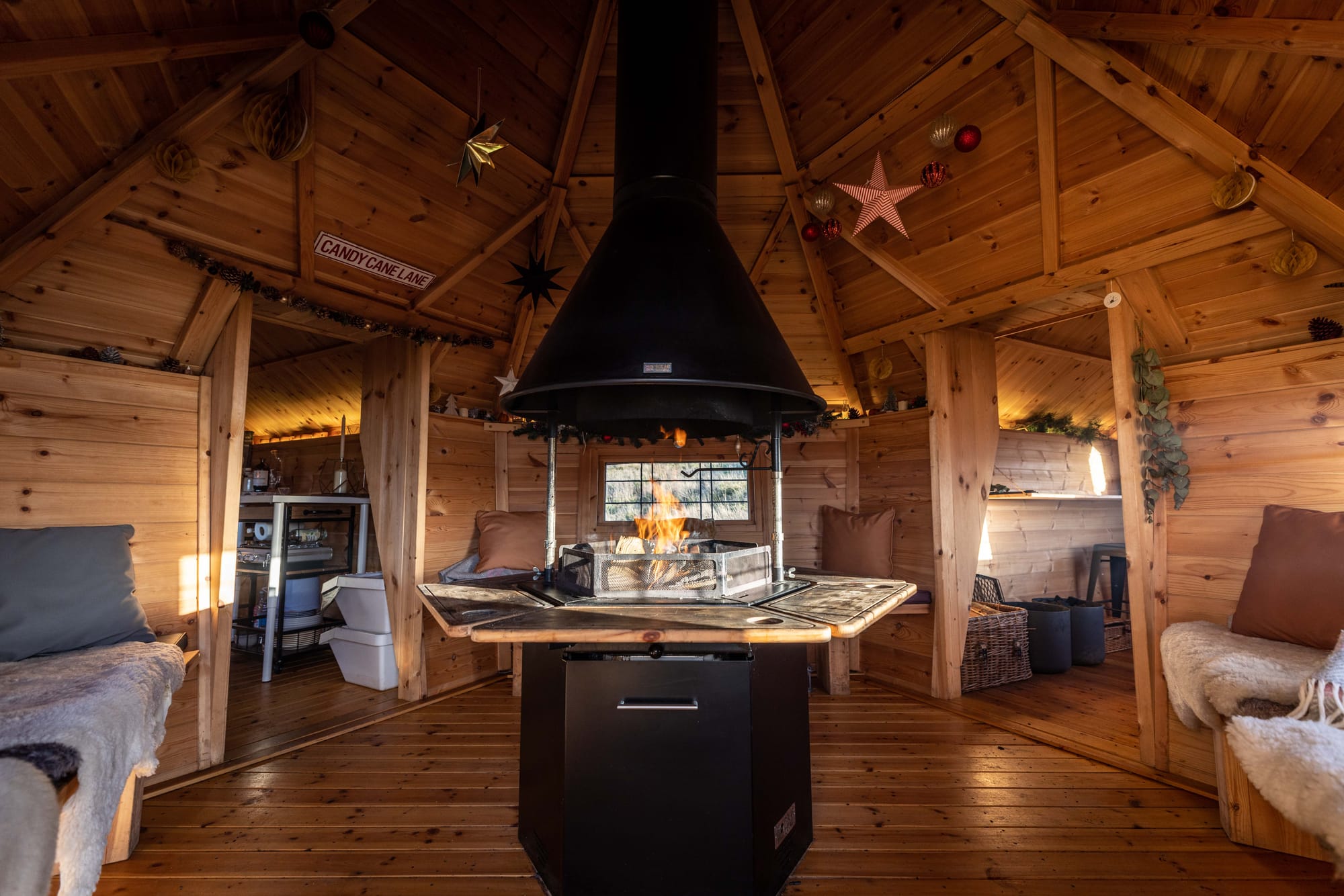 The wooden interiors of The Hide at Lindores with a roaring open fire and grill in the centre