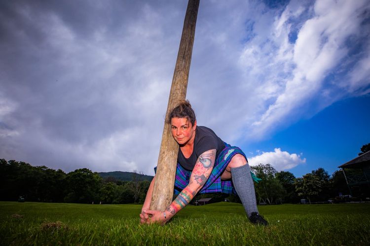 Rebecca Maeule holding a caber while wearing a kilt.