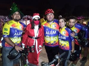Papai Noel de bicicleta levando o presente da inclusão