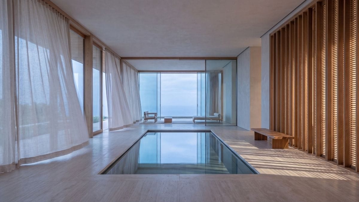 Airy minimalist timber pavilion with translucent linen screens and shallow reflecting basin.