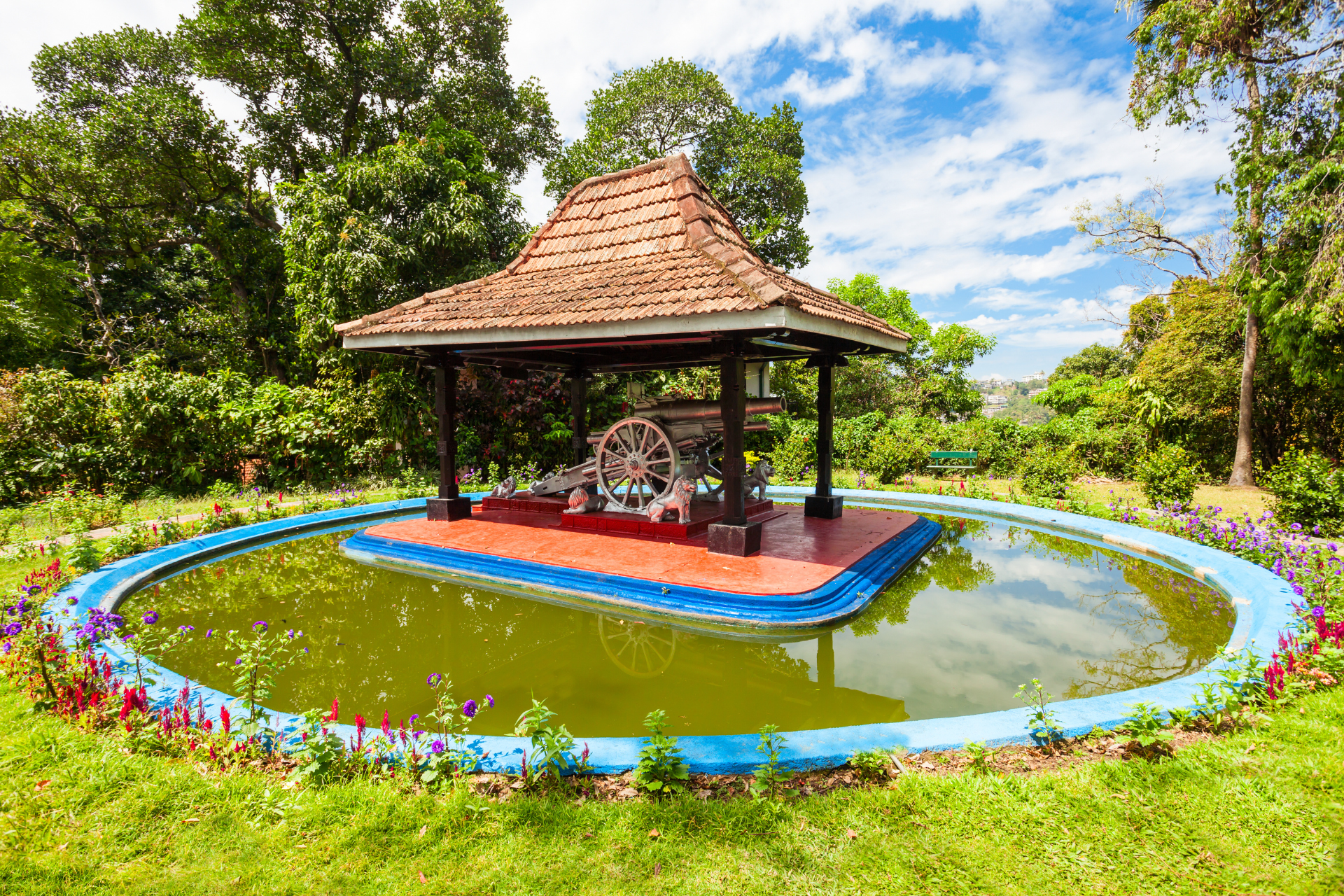 A pond in Wales Royal Park in Kandy, Sri Lanka, with a canon inside a shelter in the middle.
