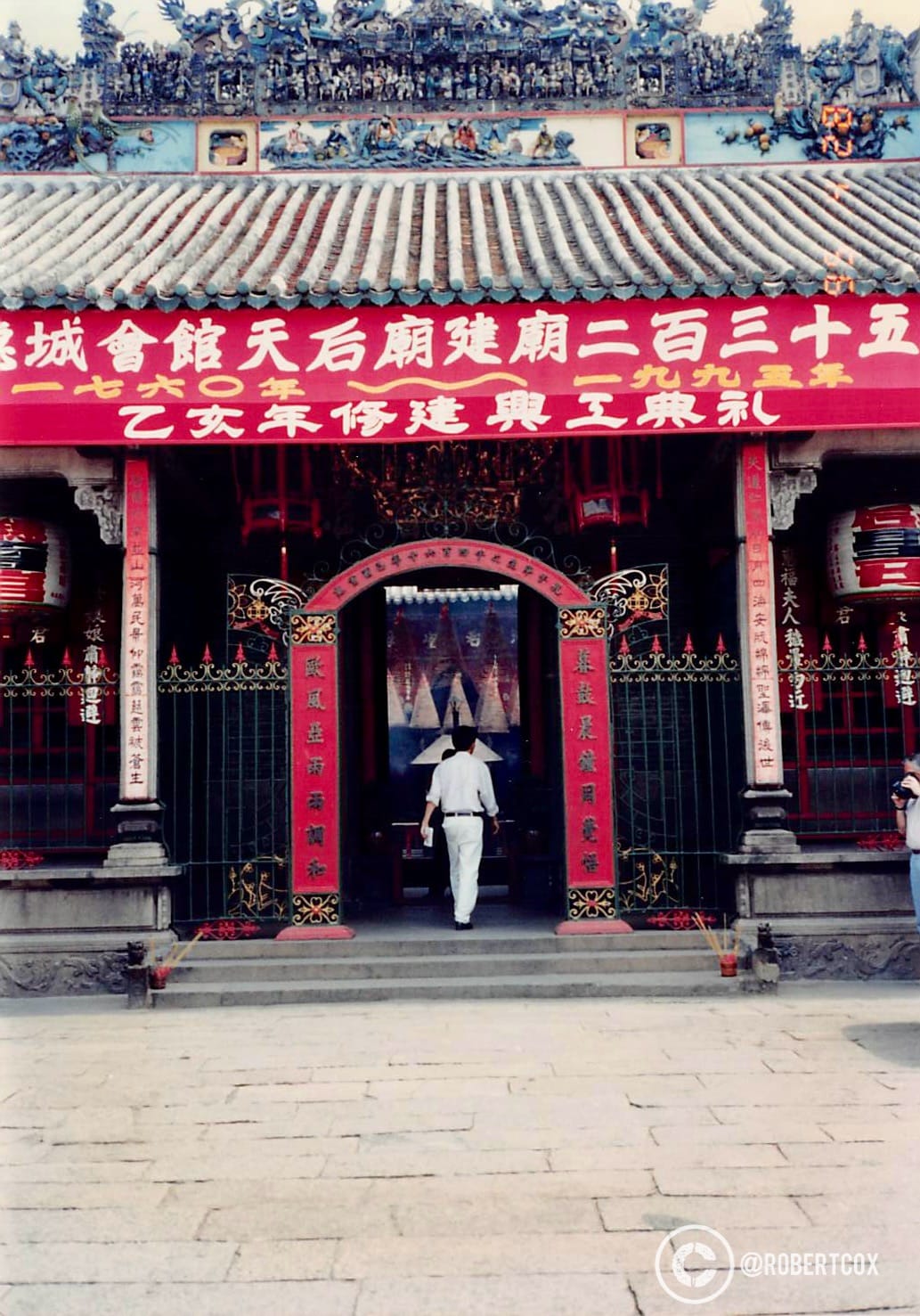 Entrance to the Thiên Hậu Pagoda, also known as the Chùa Bà Thiên Hậu, located in Ho Chi Minh City, Vietnam. The pagoda is dedicated to Thiên Hậu, the Chinese sea goddess, and is a significant cultural and religious site for the Chinese-Vietnamese community. The architecture features traditional Chinese elements, such as the tiled roof with intricate decorations and the red and gold color scheme, symbolizing good fortune and prosperity.
