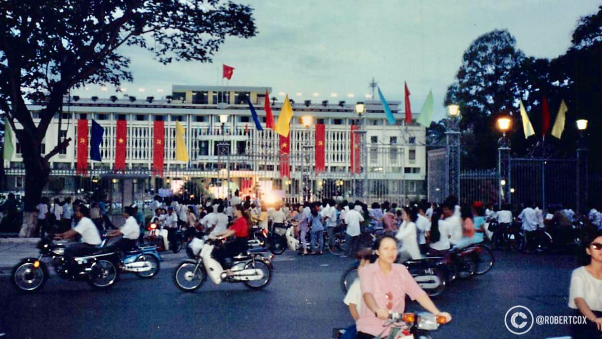 Crowd in front of Reunification Palace in Saigon. The original Tank 843 (T-54B) and Tank 390 (Type 59) were still on display at the palace in 1995 but the palace was closed to the public due to for the 20th Anniversary celebrations. The presence of many motorbikes reflects the common mode of transportation in Vietnam during that period.