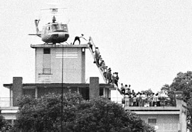 This iconic black-and-white photo depicts the evacuation of Saigon on April 29, 1975, during the Fall of Saigon, marking the end of the Vietnam War. The image, often credited to Dutch photojournalist Hubert van Es, shows a U.S. helicopter (a UH-1 Huey) on the roof of a building at 22 Gia Long Street (now Lý Tự Trọng Street), near the U.S. Embassy in Saigon. The building was a CIA safe house, not the embassy itself, though it's frequently misidentified as such in popular narratives. A ladder extends from the helicopter to the rooftop, where Vietnamese civilians are desperately climbing to escape as North Vietnamese forces closed in on the city. Many did not make it out (see video below). (April 29, 1975)