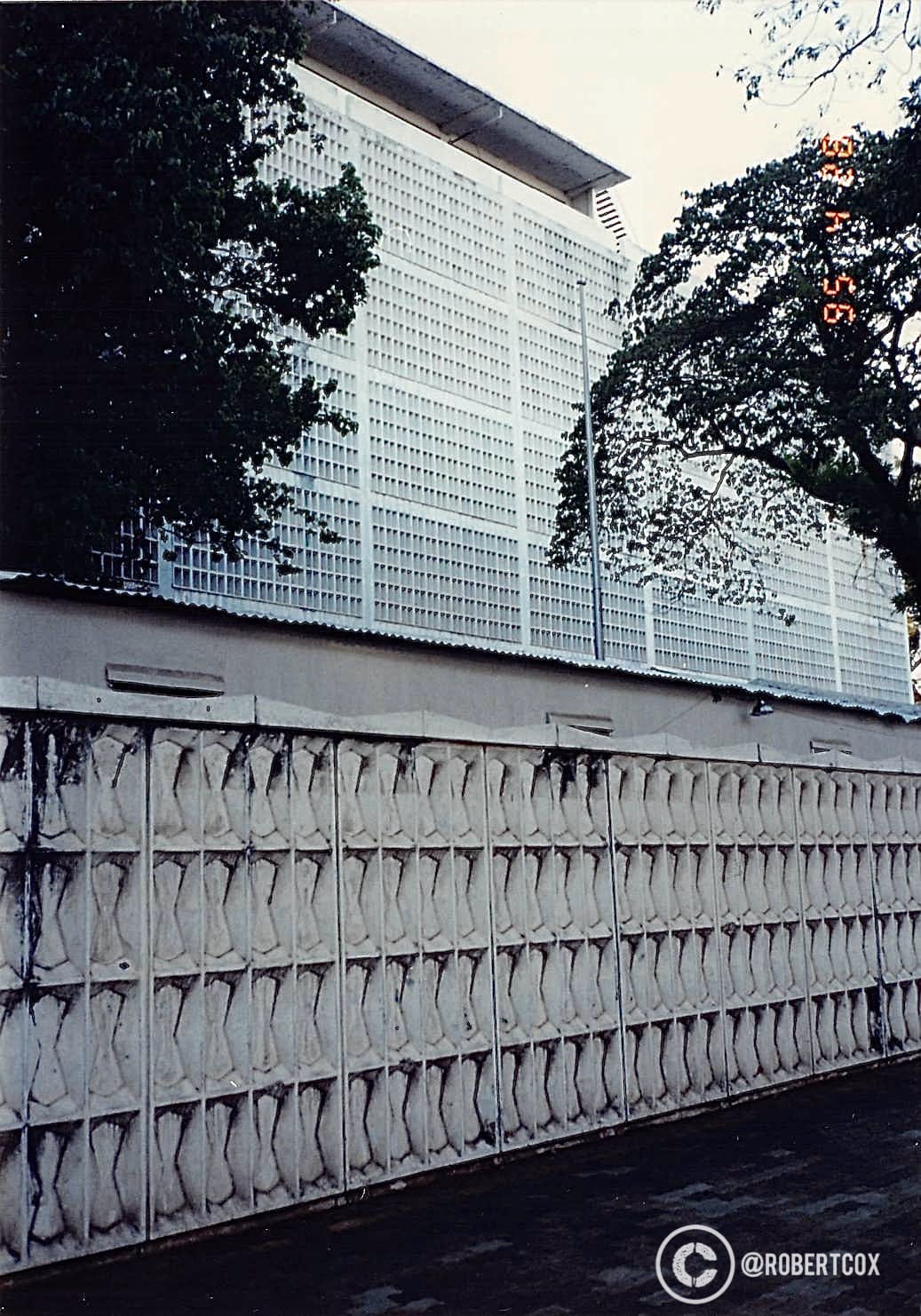 The exterior of the former U.S. Embassy in Saigon. The distinctive wall with its geometric pattern and the gate match historical images of the embassy compound. The embassy building itself was demolished in the late 1990s, but in 1995, it was still standing, though no longer in use as an embassy after the U.S. withdrawal in 1975. (April 29, 1995)