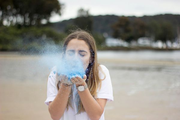 woman blowing dust from palms of her hands