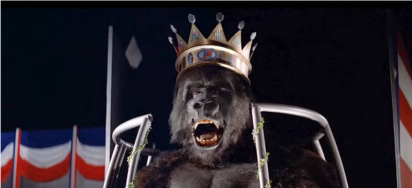 still from King Kong 1976 in which we see Kong imprisoned in New York inside a cage and forced to wear a crown