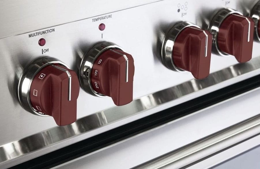 Induction stove with large red control knobs.