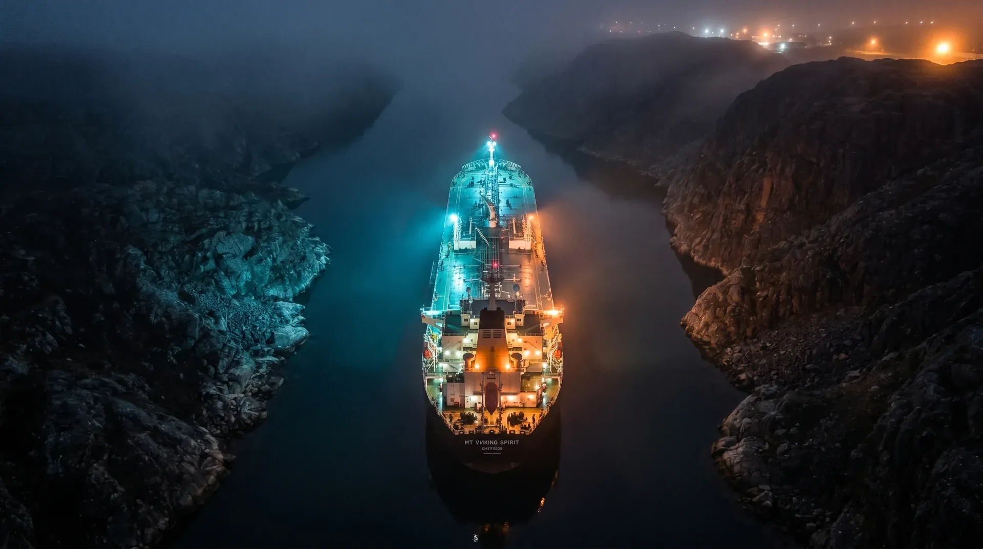 Tanker MT Viking Spirit verlicht in nauw bergpas tussen rotswanden bij nacht