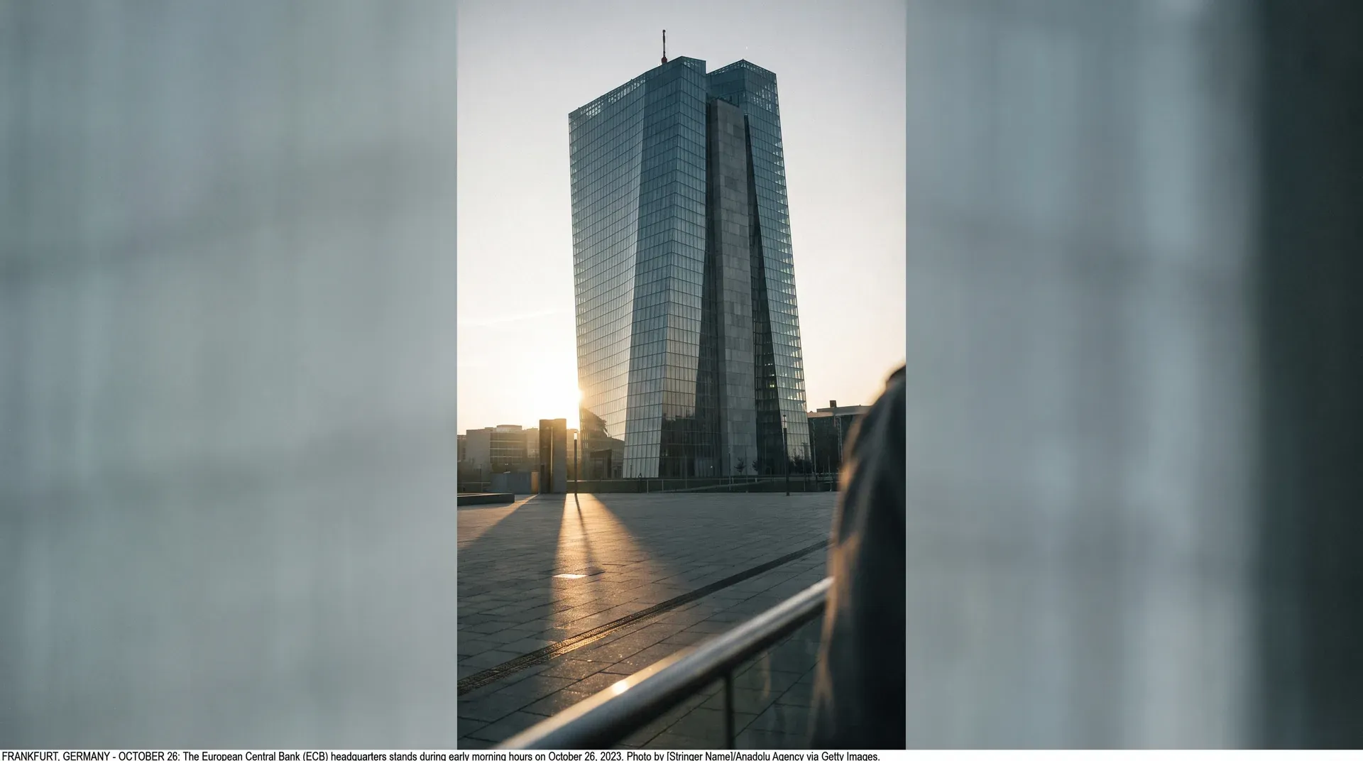 ECB-hoofdkantoor Frankfurt onder zonsopgang, glazen wolkenkrabber op plein, gouden licht op tegels