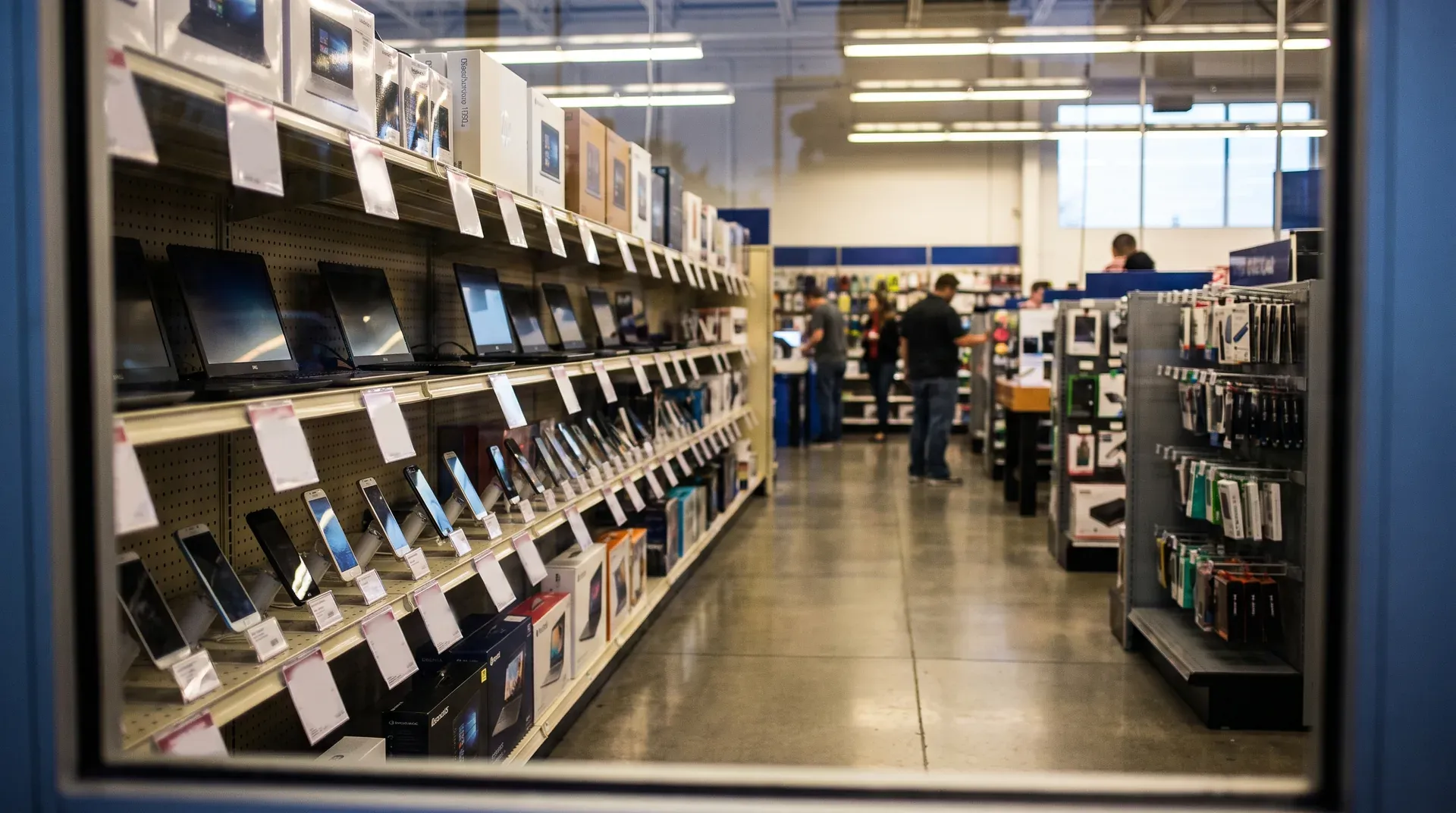 Elektronicawinkel met laptops en computers op display, klanten winkelen in groot warenhuis.