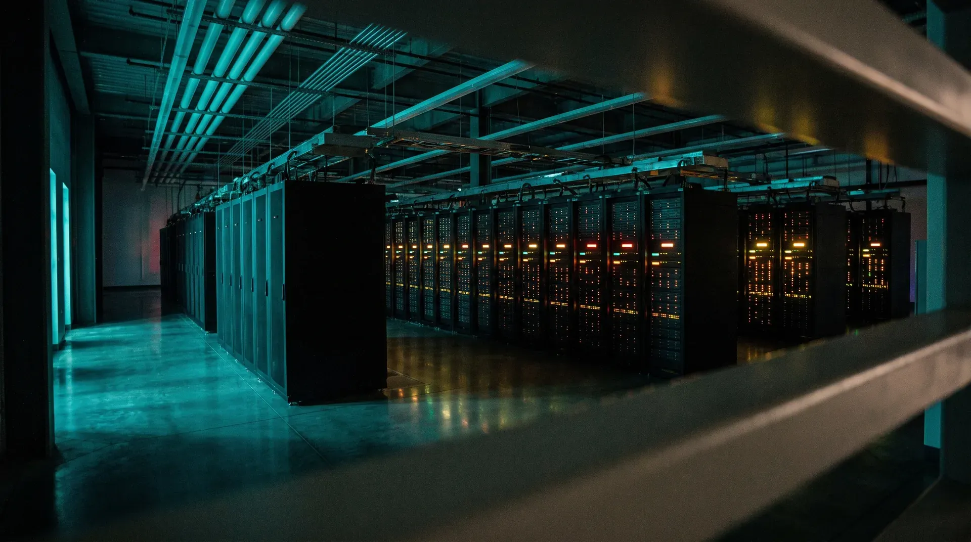 Moderne serverruimte met lange rijen zwarte racks en gloeiende indicator-LEDs onder cyaan neonverlichting