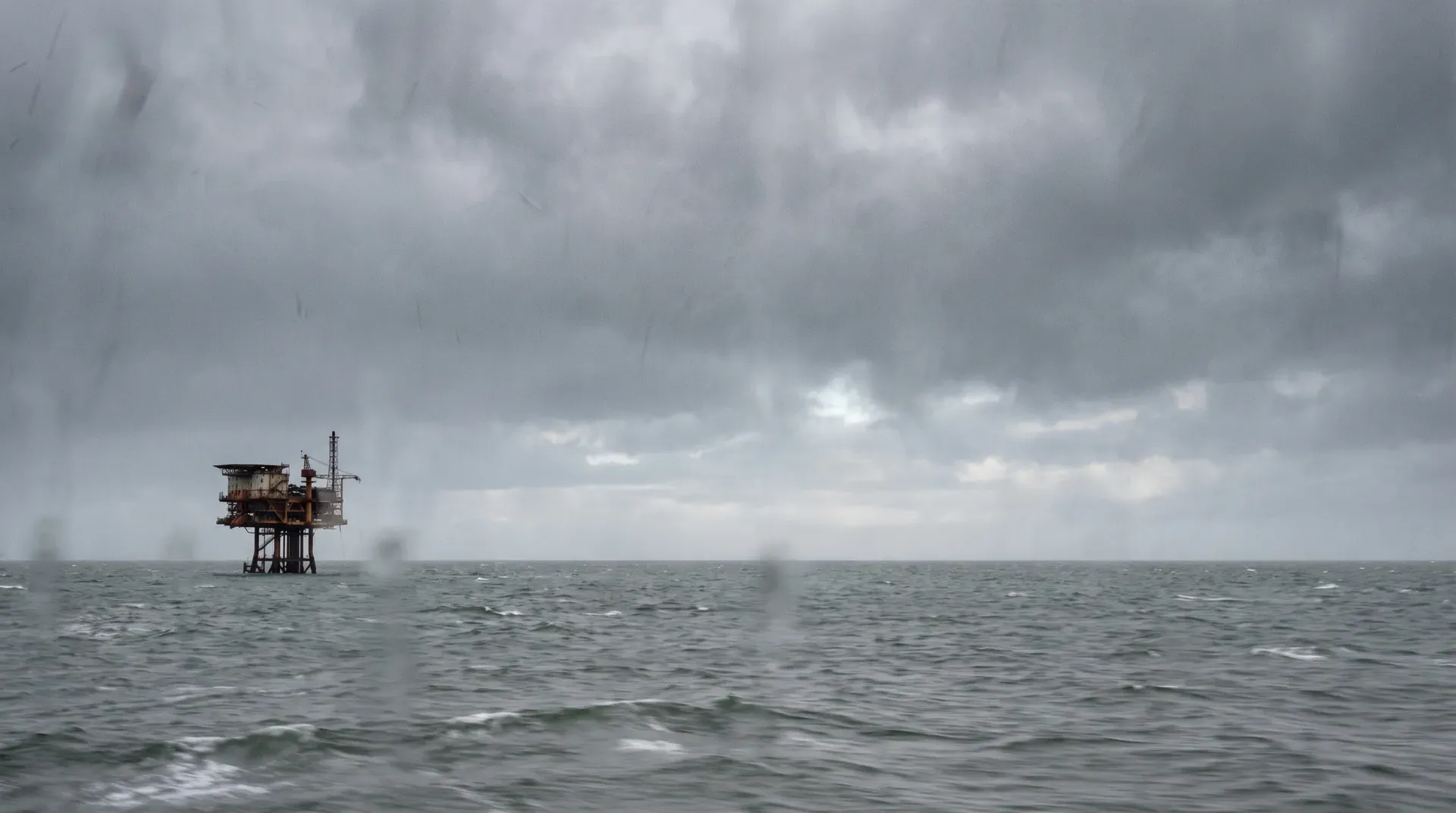 Oliewinningsplatform op zee onder bewolkte hemel met golven op voorgrond.