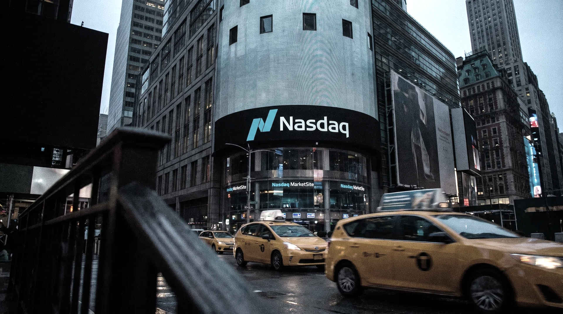 NASDAQ-gebouw Times Square New York met geel taxicabs op regenachtige straat bij schemering