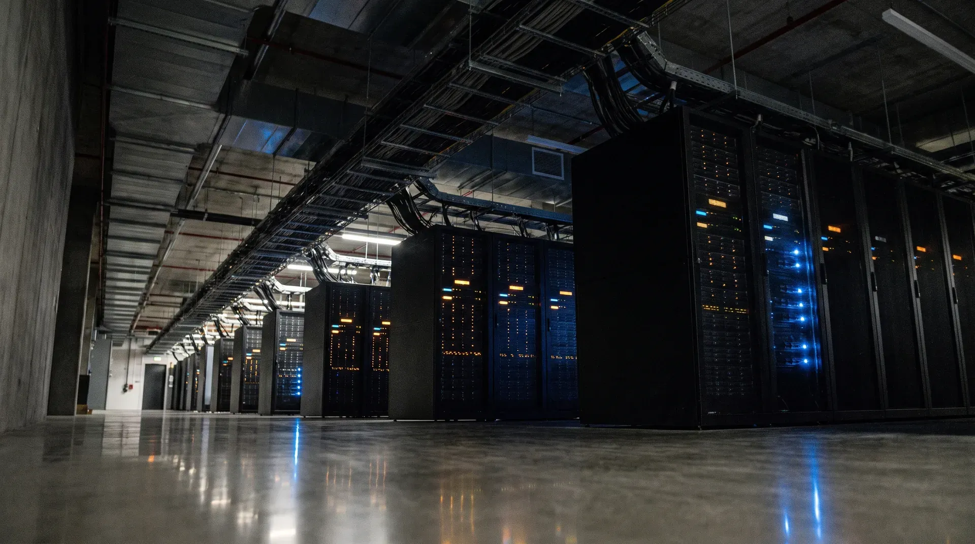 Moderne serverruimte met zwarte racks en blauwe LED-indicatoren onder industrieel plafond